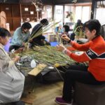 熱心にマコモの飾りづくりに取り組む参加者