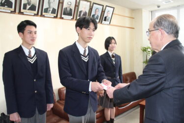 坂手会長に売上金の一部を手渡す森本さん=岡山県津山市で