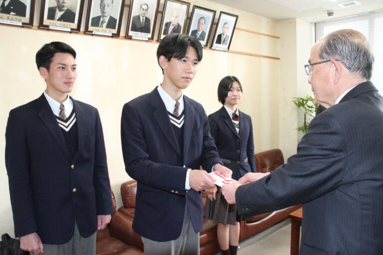 坂手会長に売上金の一部を手渡す森本さん=岡山県津山市で