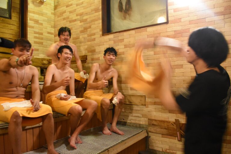 タオルで熱風を送ってもらい、サウナを楽しむ台湾の学生ら