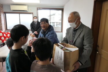 立正青葉学園にお菓子のセットを贈る平山会長（中央）ら＝岡山県津山市で