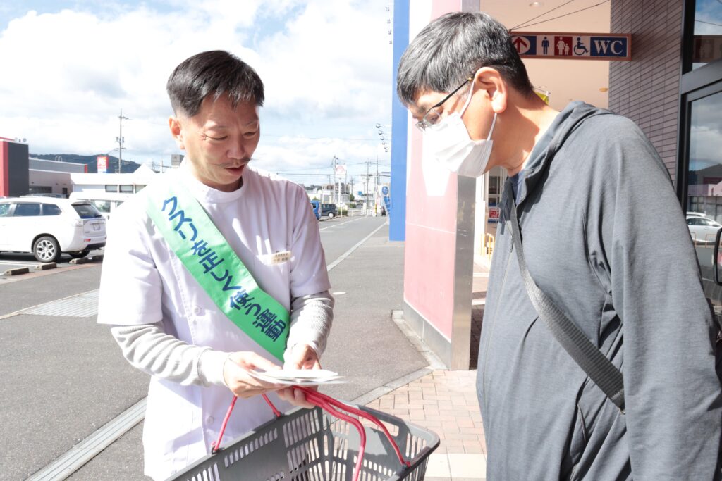 会員たちの呼びかけに耳を傾ける買い物客