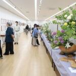 生け花や絵画、書などさまざまな展示作品を観賞する来場者＝岡山県津山市で