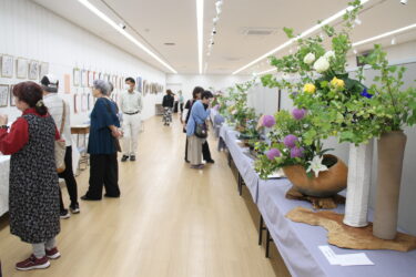 生け花や絵画、書などさまざまな展示作品を観賞する来場者＝岡山県津山市で