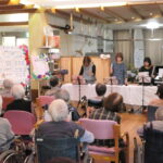 ボランティアの演奏に聴き入る参加者=岡山県津山市で