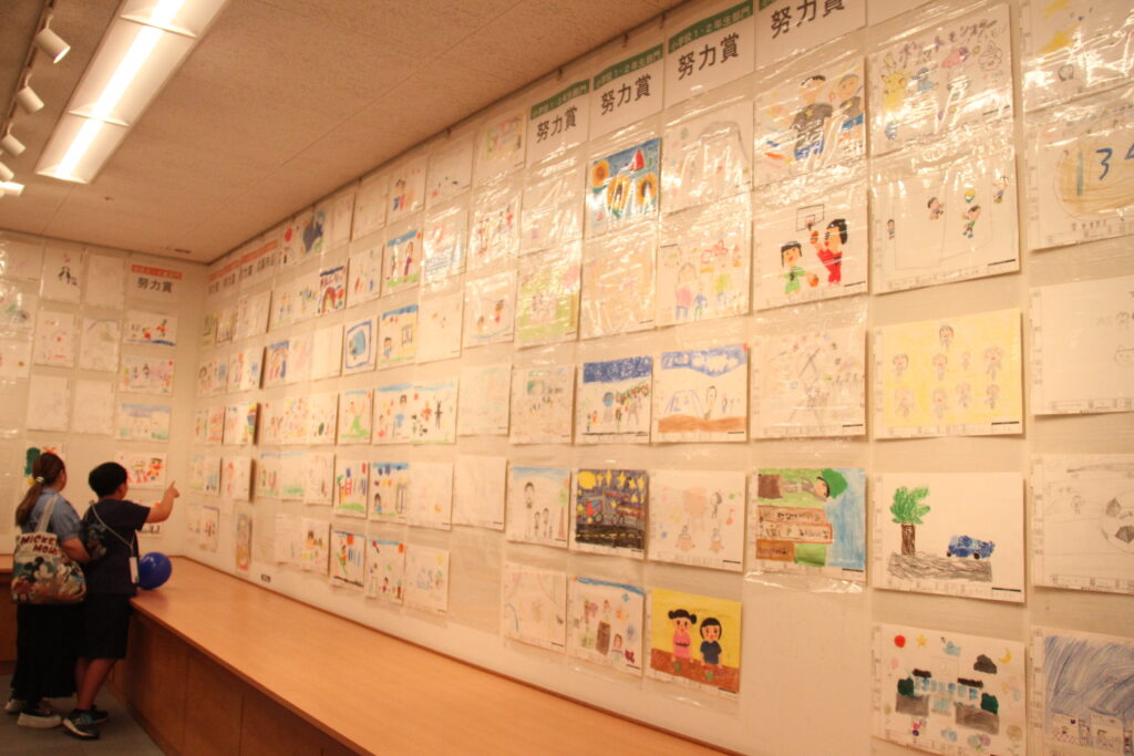 ずらりと並んだ作品を鑑賞する来場者