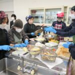 協力して昼食をつくる生徒とお年寄りたち=岡山県津山市で