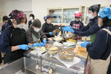 協力して昼食をつくる生徒とお年寄りたち=岡山県津山市で