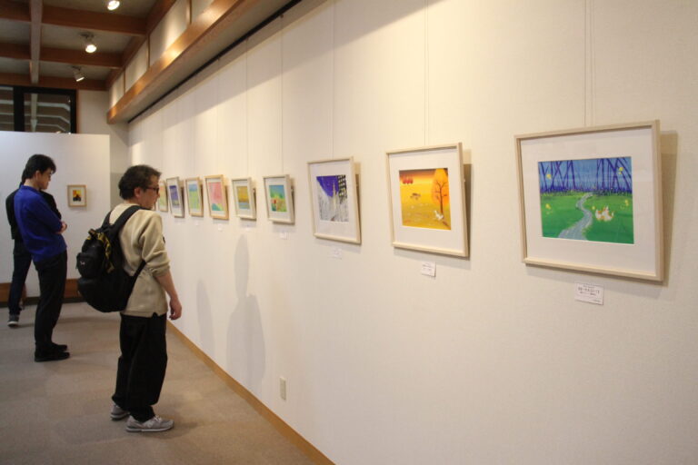 柔らかなタッチのイラストに見入る来場者＝岡山県津山市で