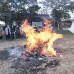 燃え盛る炎に古筆を投げ入れる小坂宮司=岡山県津山市で