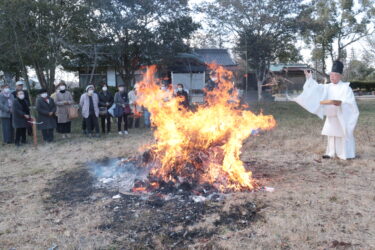 燃え盛る炎に古筆を投げ入れる小坂宮司=岡山県津山市で