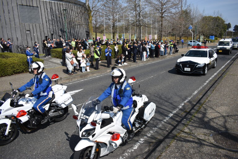 参加者に見送られて広報活動に出発する白バイやパトカー＝岡山県津山市で