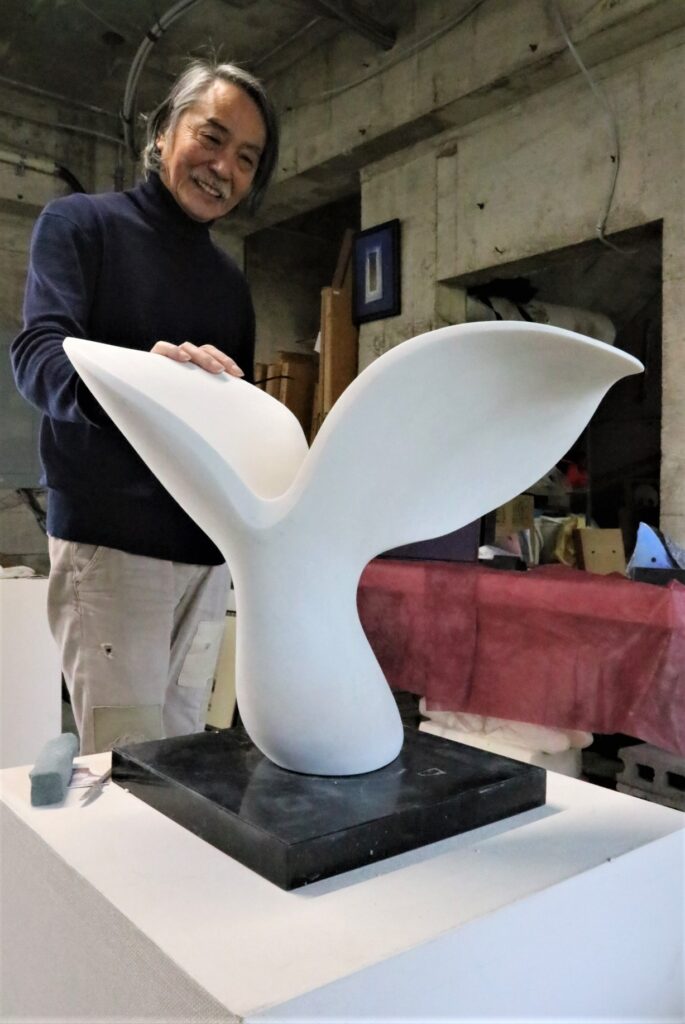 石彫「風の舞」の縮小サイズ作品と武藤さん