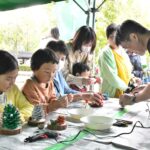 木の実を使った置物づくりに挑戦する家族連れ=岡山県津山市で