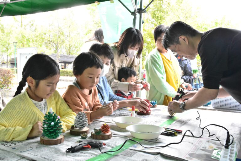 木の実を使った置物づくりに挑戦する家族連れ=岡山県津山市で