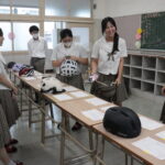 さまざまなデザインのヘルメットを手に取る高校生＝岡山県津山市で