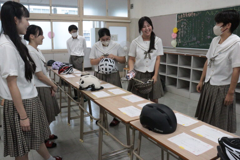 さまざまなデザインのヘルメットを手に取る高校生＝岡山県津山市で