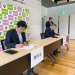 協定書に署名する萩原市長と坂田会長