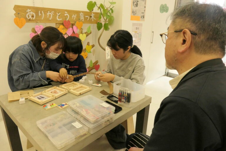 木製のフォトスタンドを作る親子連れら＝岡山県津山市で