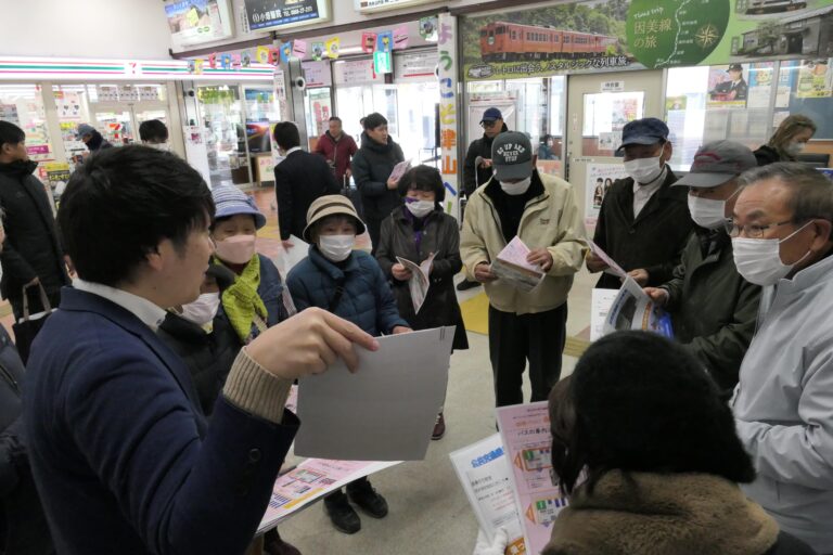 公共交通について説明を受ける高齢者たち=岡山県津山市、津山駅で