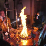 護摩の火の前で心願成就を祈る参拝者=岡山県津山市で