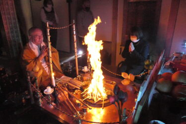 護摩の火の前で心願成就を祈る参拝者=岡山県津山市で