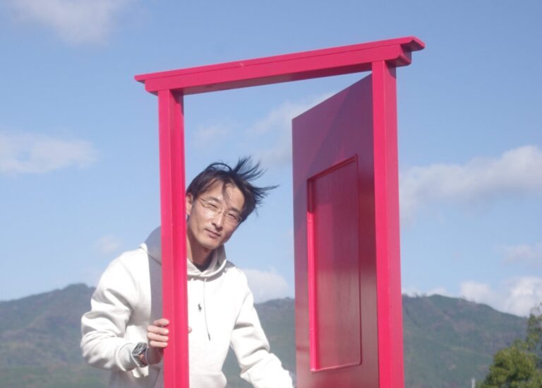 グリーンヒルズ津山に設置されたピンク色のドアと丸山さん=岡山県津山市大田のグリーンヒルズ津山で