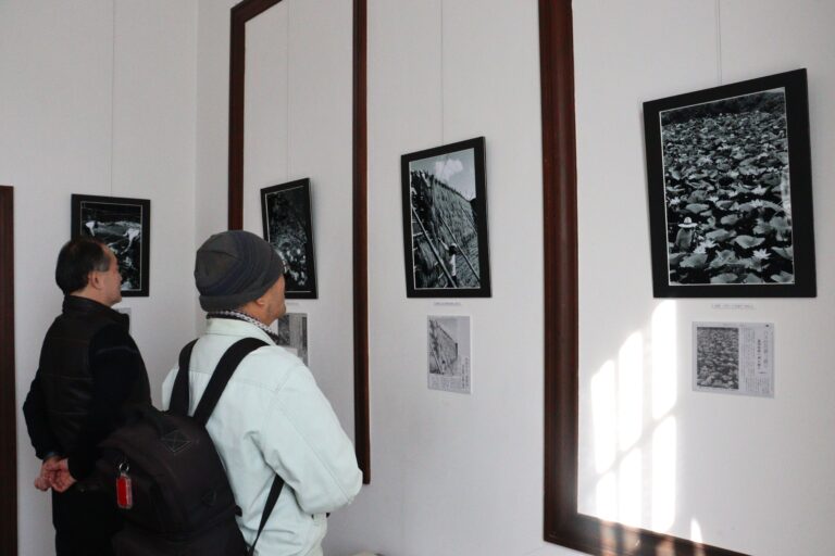 フィルム撮影したモノクロ写真に見入る来場者=岡山県津山市で