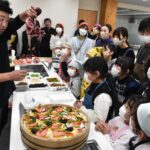 光畑さんから食材の説明を受ける子どもたち=岡山県真庭市で