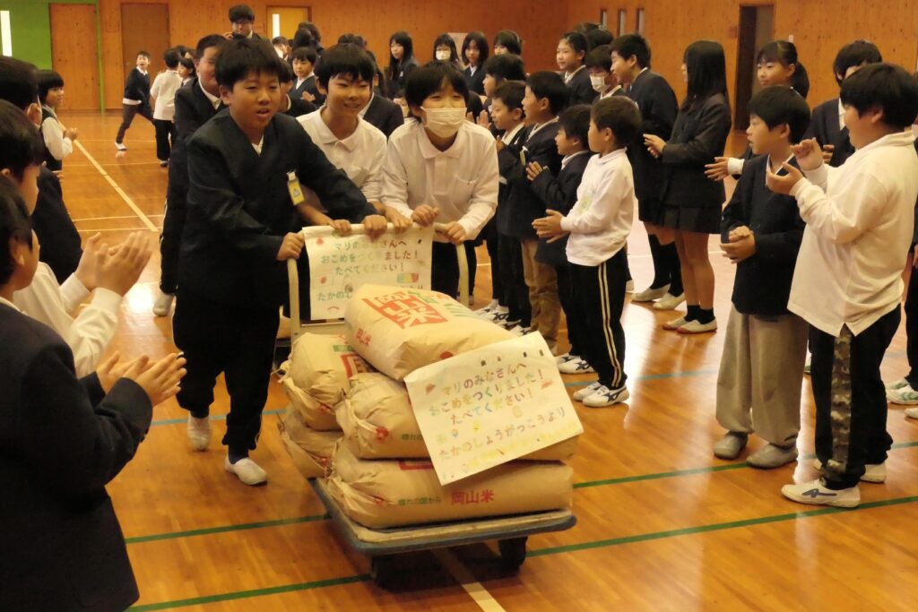 マリ共和国に贈る米を運ぶ児童たち