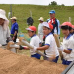 塩ビパイプに“とっこ土”を入れる児童