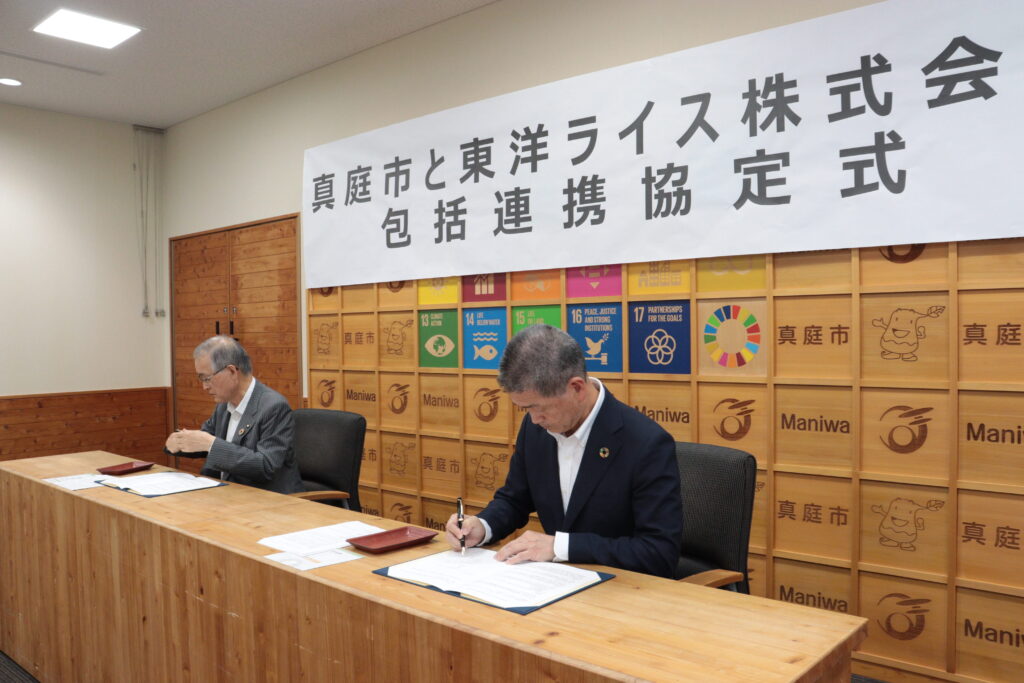 包括連携協定を締結し、協定書に署名する東洋ライスの阪本哲生社長(右)と太田昇真庭市長