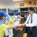 参加者の呼びかけに耳を傾ける高校生＝岡山県津山市、JR津山駅前で