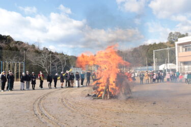 勢いを増すとんどの炎を見つめる子どもたち=岡山県津山市
