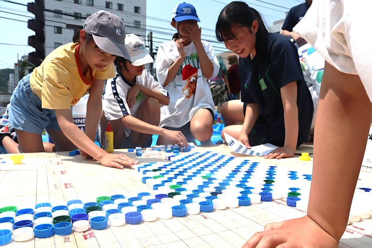 ペットボトルのキャップでモザイクアートを制作する参加者=岡山県津山市で