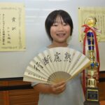 小学生女子将棋名人戦全国大会の優勝トロフィーと扇子を手にする土山さん=岡山県美咲町で