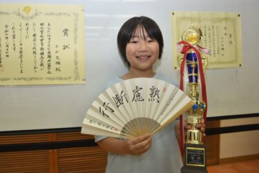 小学生女子将棋名人戦全国大会の優勝トロフィーと扇子を手にする土山さん=岡山県美咲町で