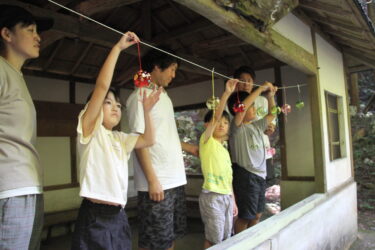 風鈴の飾り付け作業に励む親子連れ＝岡山県津山市で