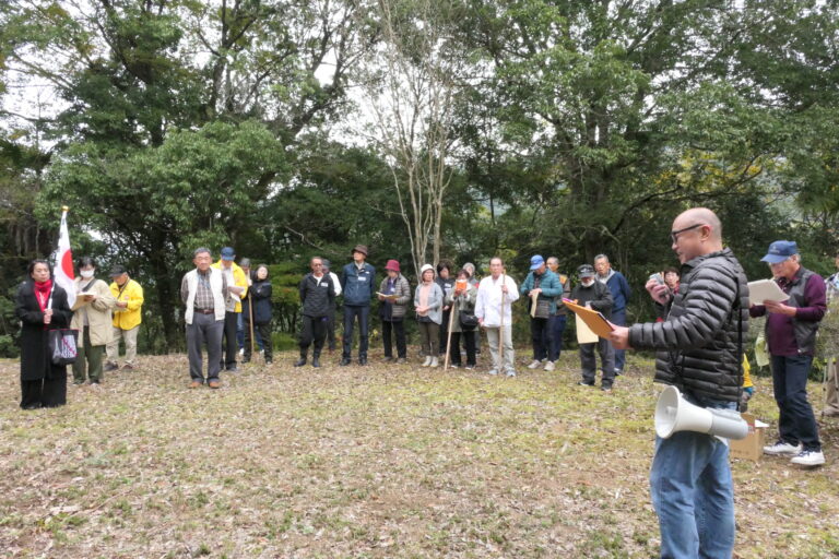 竹内流古武道と創始者・久盛にまつわる話に耳を傾ける参加者＝岡山県美咲町、一ノ瀬城跡で