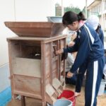 唐箕を使って籾に混ざったわらくずなどを取り出す作業を行う子どもたち