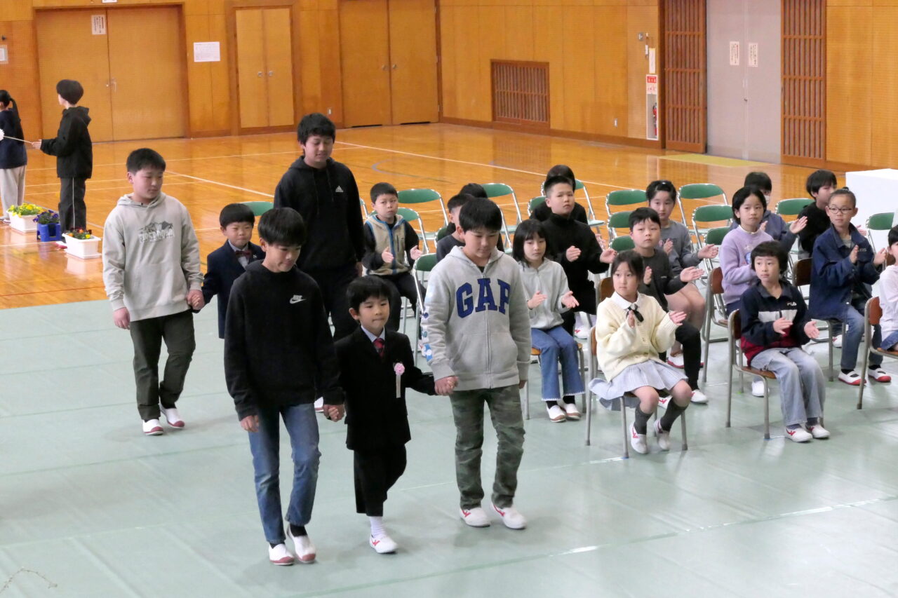 拍手で迎えられ入場する清泉小最後の新入生＝岡山県津山市で