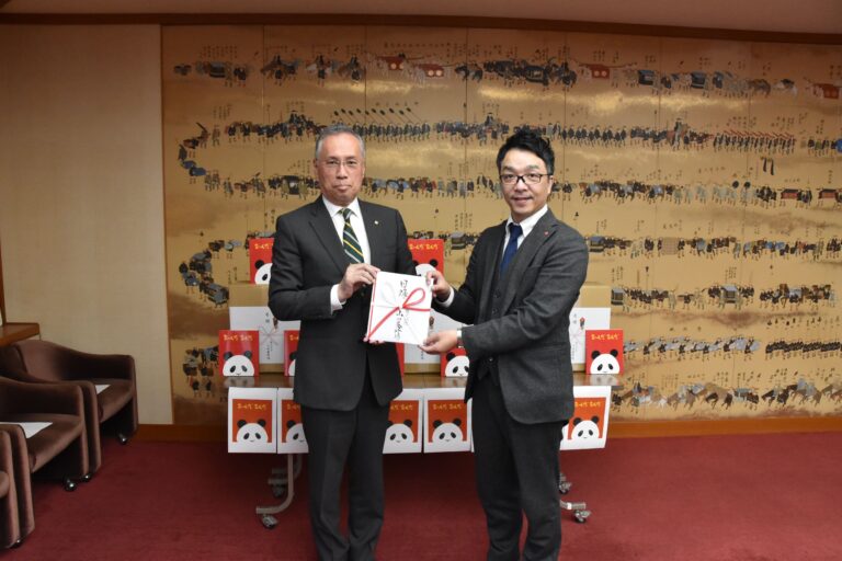 目録を手にする山田養蜂場の守安取締役執行役員（右）と谷口市長