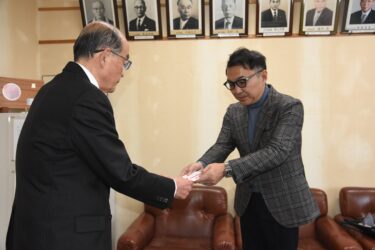 髙山社長（右）から目録を受け取る坂手会長=岡山県津山市で