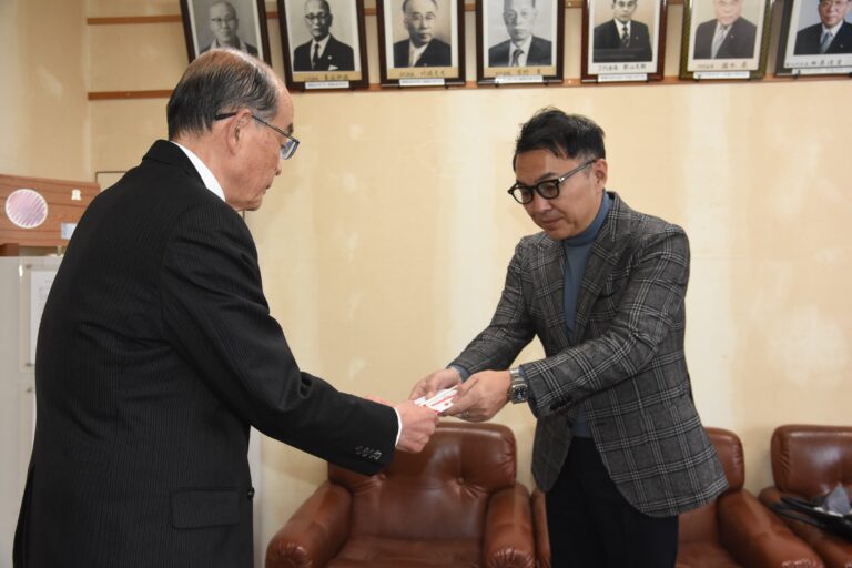 髙山社長（右）から目録を受け取る坂手会長=岡山県津山市で