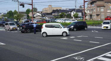 手信号で車を誘導する津山署員=岡山県津山市で