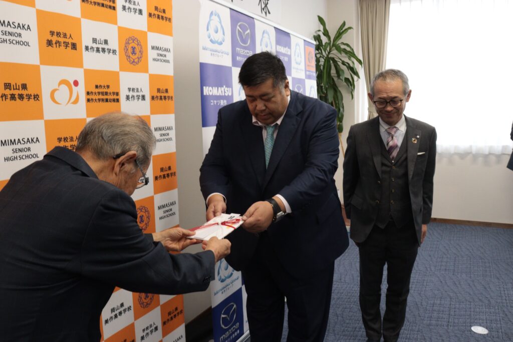 目録を手渡す川嶋社長(左)ら