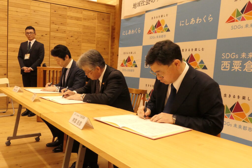 連携協定書にサインする3者代表