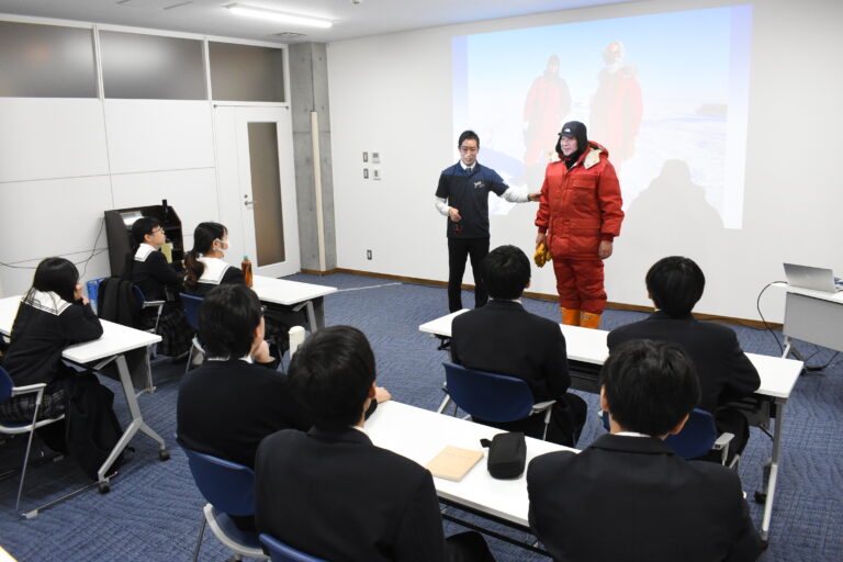 観測隊の防寒着について説明する堀川さん（正面左）=岡山県津山市で