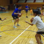 選手とドリブルの練習をする小学生たち=岡山県津山市で