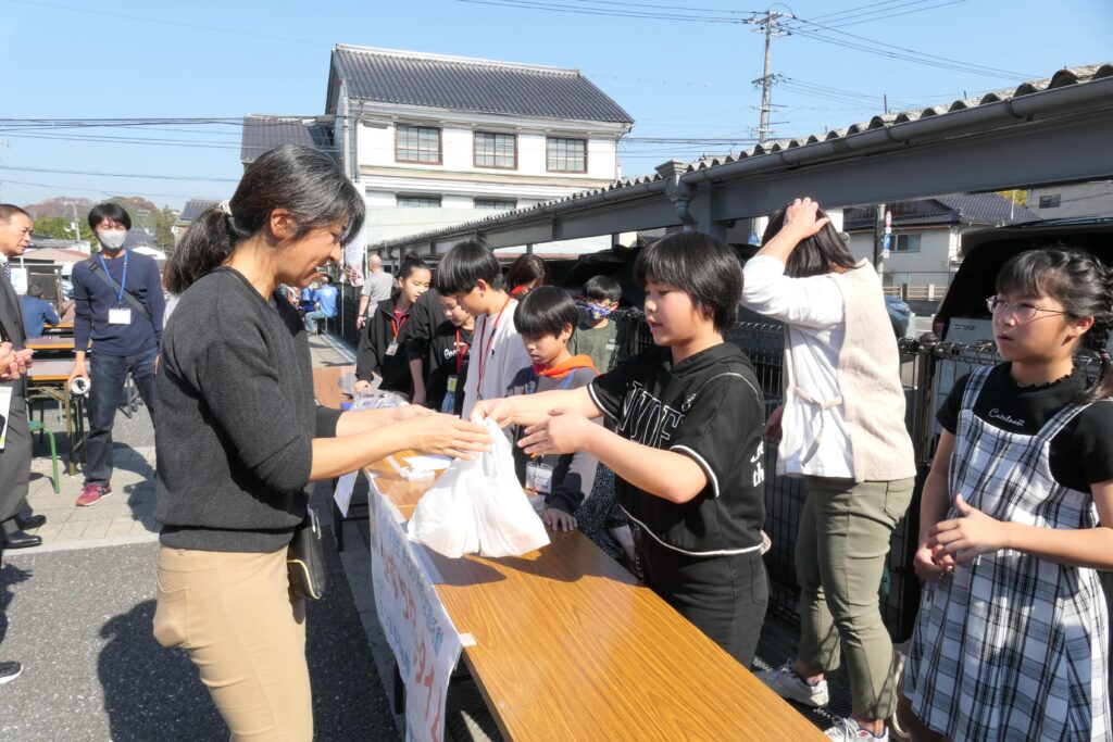 元気良く商品を売る小学生たち